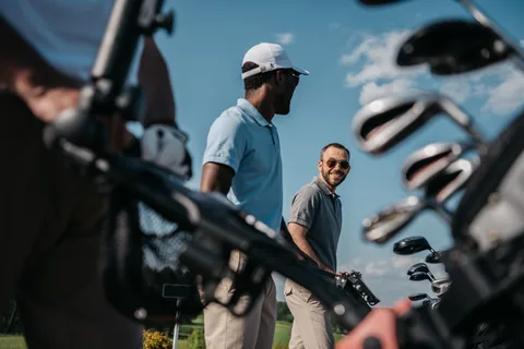 Two golfers on the course with their clubs