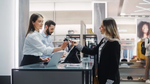 Shopper tapping a phone to pay at a retail checkout counter