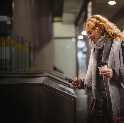 Commuter tapping a phone at a transit fare gate