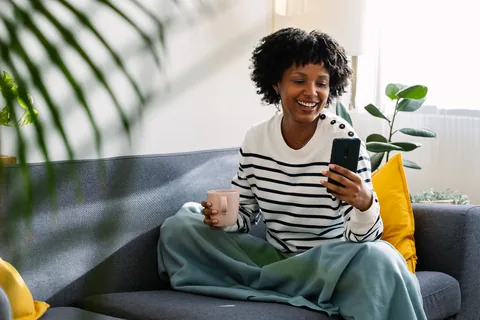 Person relaxing on a couch checking their phone